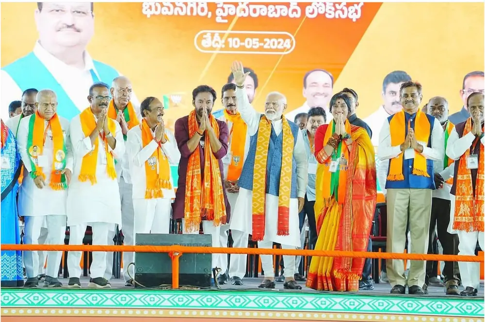 Leaders greeting the crowd with folded hands on a stage