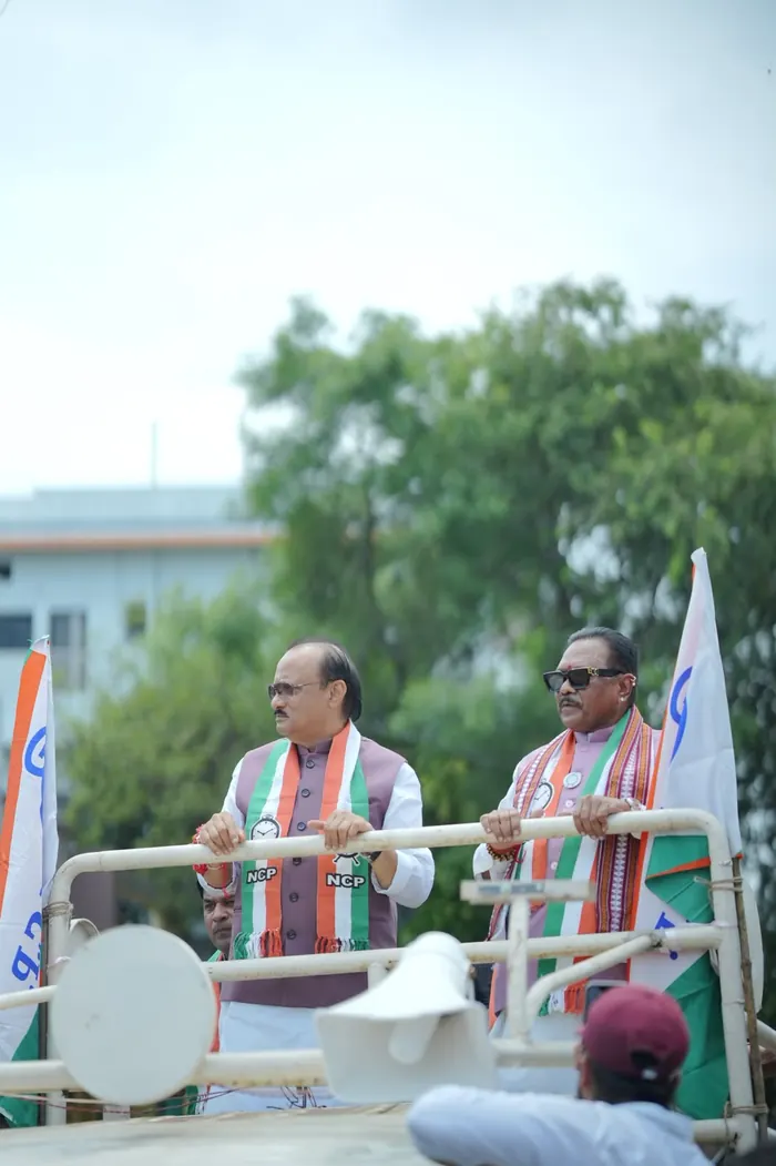 Two leaders standing on a campaign vehicle during a roadshow